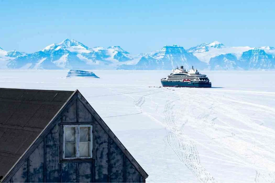 Expedition cruise ship crossing an Arctic landscape